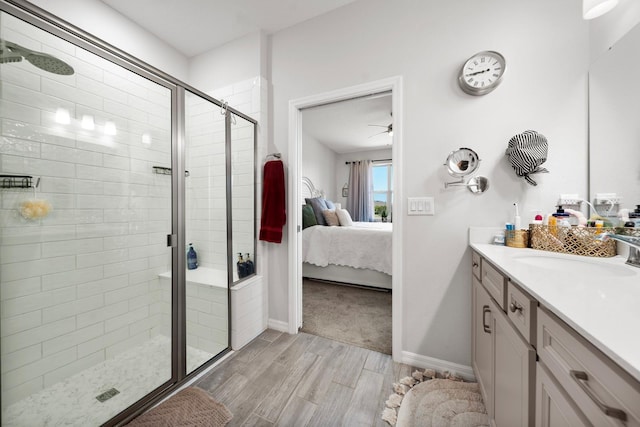 ensuite bathroom featuring vanity, ceiling fan, wood finish floors, connected bathroom, and a stall shower