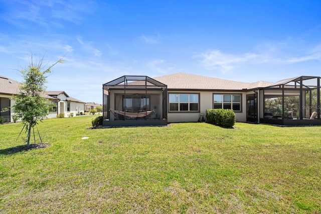 back of house with a sunroom, glass enclosure, stucco siding, and a yard