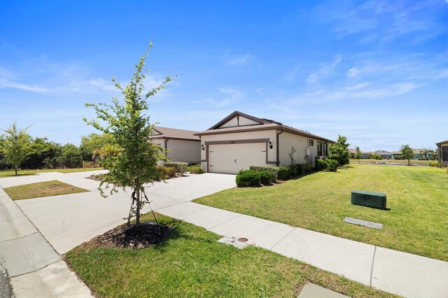 ranch-style home with a garage, a front lawn, stucco siding, and driveway