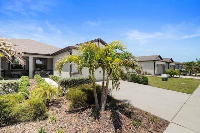 view of front facade featuring a garage, stucco siding, and driveway
