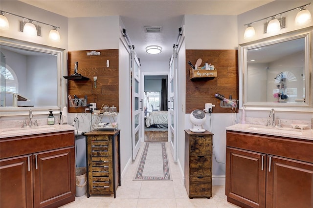 ensuite bathroom with a sink, two vanities, and visible vents