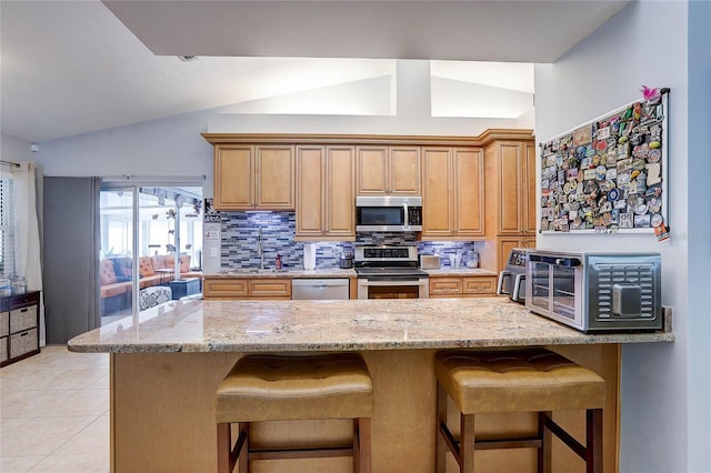 kitchen with appliances with stainless steel finishes, backsplash, vaulted ceiling, and light stone counters