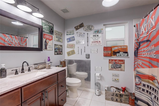 bathroom featuring tile patterned flooring, vanity, toilet, baseboards, and visible vents