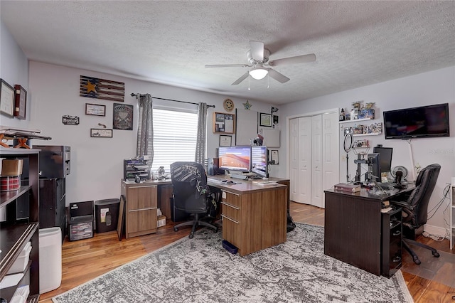 office area featuring light wood-style floors, a textured ceiling, and ceiling fan