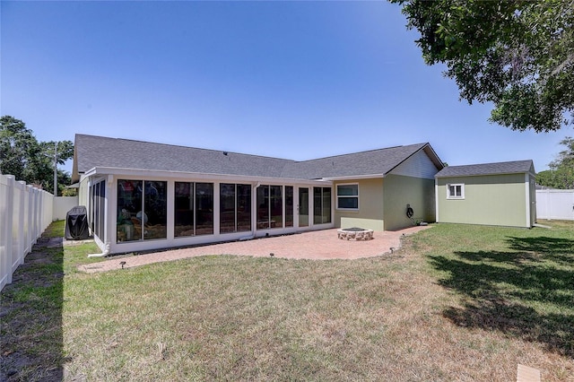 back of property featuring a lawn, a fenced backyard, a patio area, and an outdoor fire pit