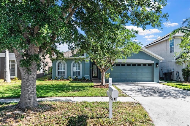 view of front of property featuring an attached garage, stucco siding, driveway, and a front lawn