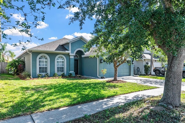 ranch-style home with a garage, a front yard, stucco siding, a shingled roof, and driveway