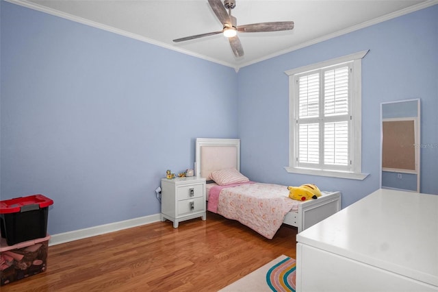 bedroom featuring crown molding, a ceiling fan, baseboards, and wood finished floors