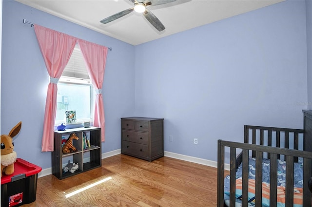 bedroom featuring baseboards, a ceiling fan, and wood finished floors