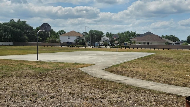 view of sport court featuring a lawn, community basketball court, and fence