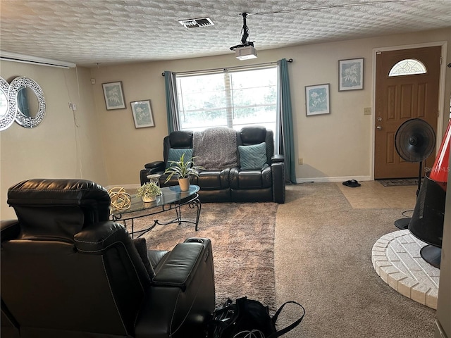 living area featuring baseboards, a wealth of natural light, a textured ceiling, and visible vents