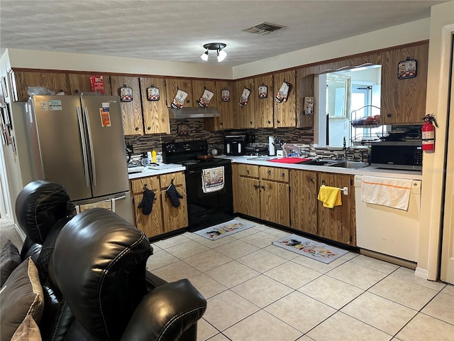 kitchen with light countertops, stainless steel appliances, decorative backsplash, light tile patterned floors, and under cabinet range hood
