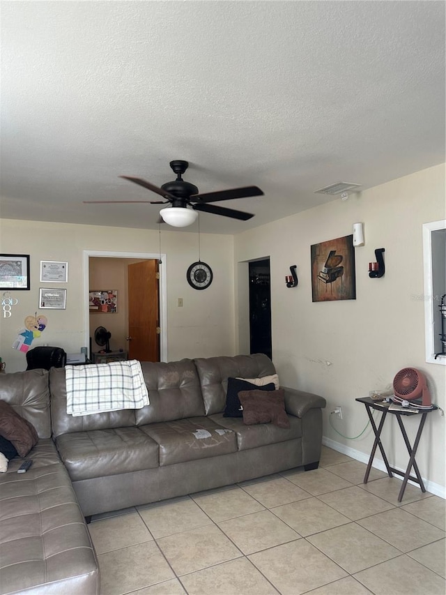 living area with baseboards, a ceiling fan, a textured ceiling, and light tile patterned floors