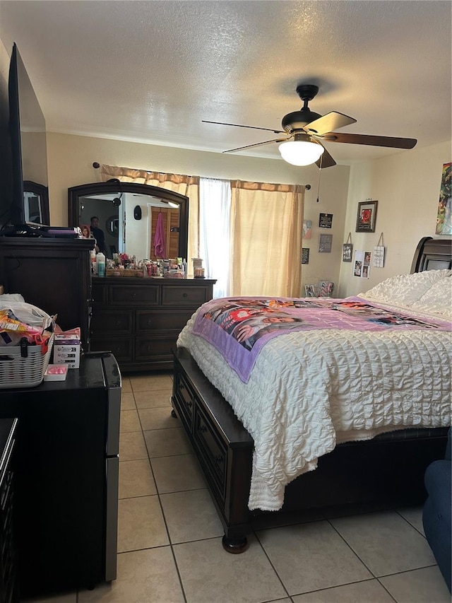 bedroom featuring a textured ceiling, ceiling fan, and light tile patterned flooring