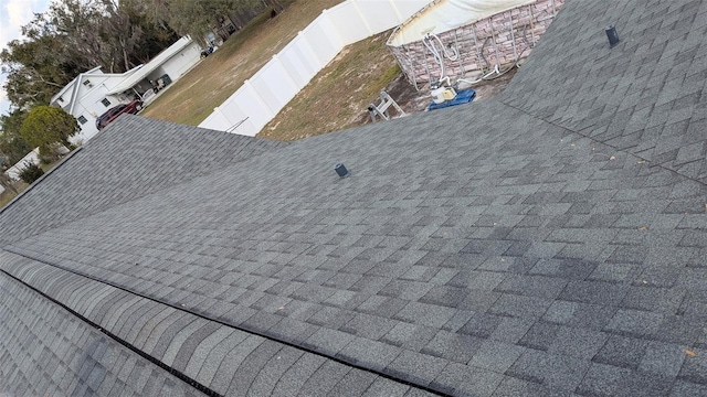 exterior details featuring fence private yard and a shingled roof
