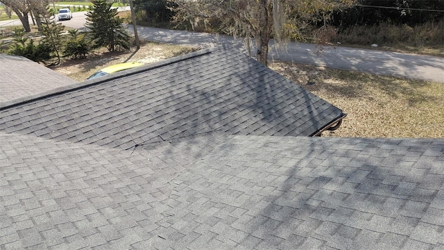 exterior details featuring roof with shingles