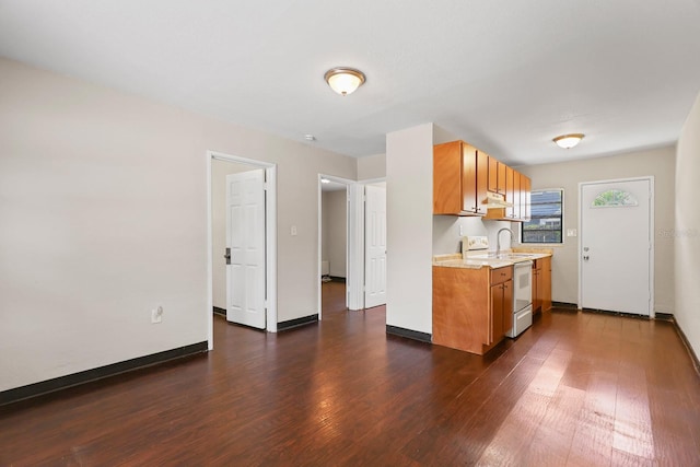 kitchen featuring white range with electric cooktop, baseboards, dark wood-style floors, light countertops, and brown cabinets