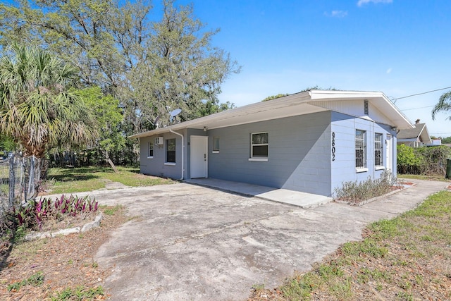 view of front of home with fence, a carport, and driveway