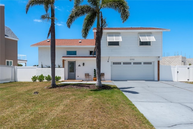 2202 Donato Dr, Belleair Beach, FL 33786 - view of front facade featuring driveway, a gate, a garage, fence, and a front lawn