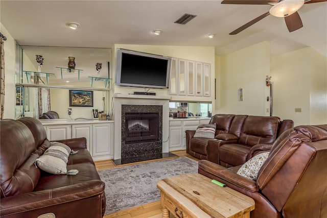 2202 Donato Dr, Belleair Beach, FL 33786 - living area with visible vents, light wood finished floors, a premium fireplace, a ceiling fan, and vaulted ceiling