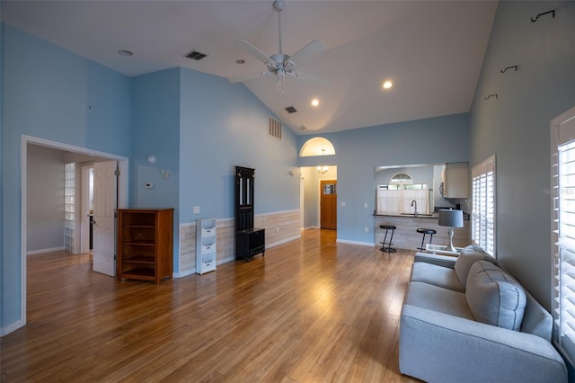 living area with visible vents, a ceiling fan, baseboards, and high vaulted ceiling