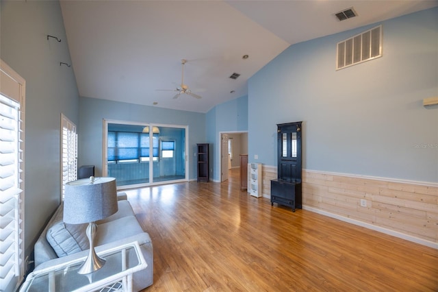 unfurnished living room featuring visible vents, a ceiling fan, light wood-style flooring, and high vaulted ceiling
