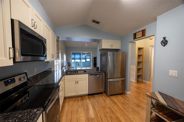 kitchen with visible vents, white cabinetry, a sink, light wood-style flooring, and stainless steel appliances