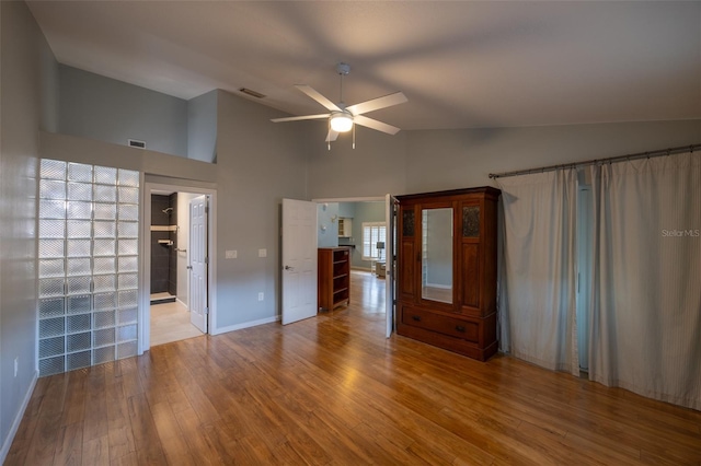 interior space with high vaulted ceiling, a ceiling fan, wood finished floors, and visible vents