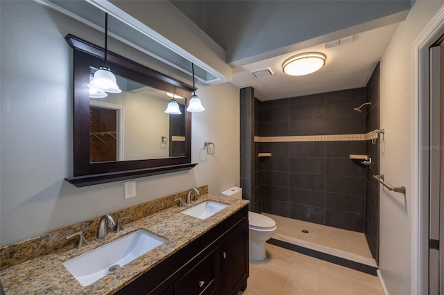 bathroom featuring a sink, toilet, and tiled shower