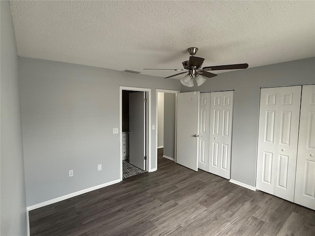 1010 Lochmont Dr, Brandon, FL 33511 - unfurnished bedroom featuring dark wood-type flooring, a textured ceiling, multiple closets, and visible vents