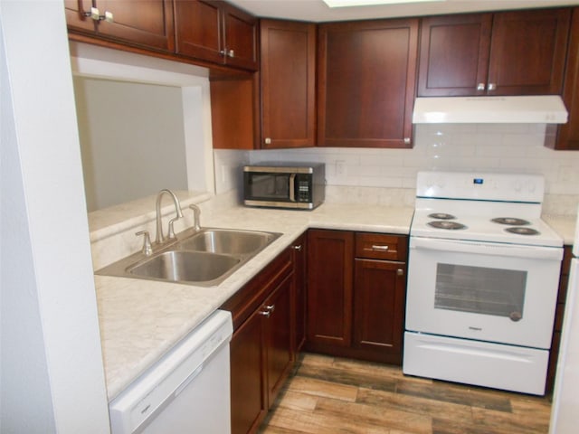 3311 Teeside Dr, New Port Richey, FL 34655 - kitchen featuring white appliances, light wood-type flooring, light countertops, under cabinet range hood, and a sink