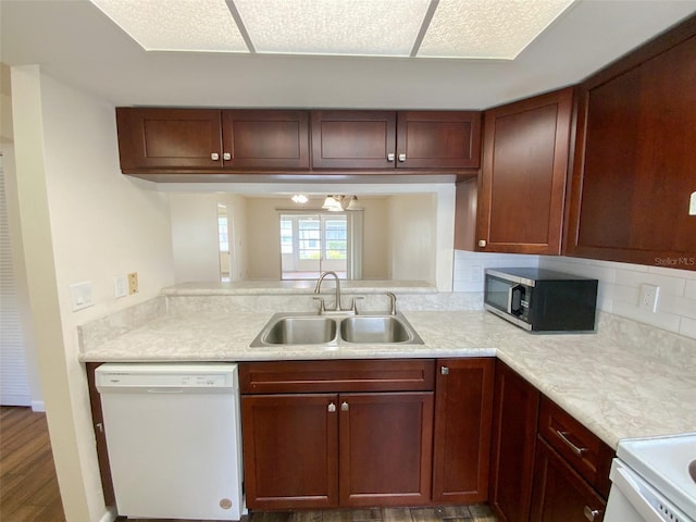 3311 Teeside Dr, New Port Richey, FL 34655 - kitchen with white dishwasher, stainless steel microwave, light countertops, backsplash, and wood finished floors