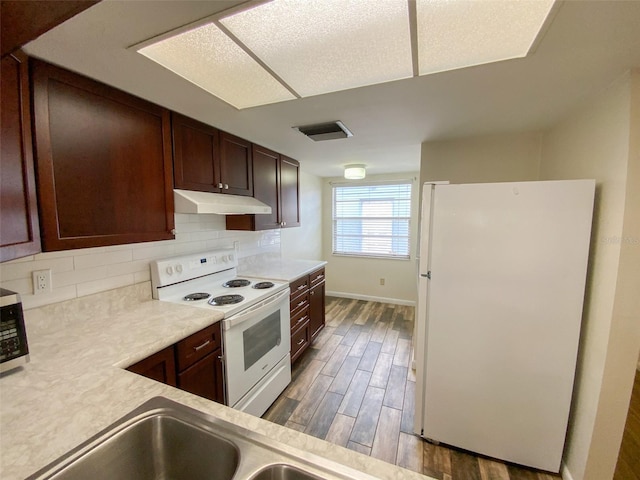 3311 Teeside Dr, New Port Richey, FL 34655 - kitchen featuring white appliances, under cabinet range hood, decorative backsplash, wood finished floors, and light countertops