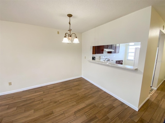 3311 Teeside Dr, New Port Richey, FL 34655 - kitchen with white electric range oven, dark wood-style floors, light countertops, hanging light fixtures, and a chandelier