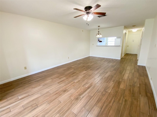 3311 Teeside Dr, New Port Richey, FL 34655 - unfurnished room featuring wood finished floors, a ceiling fan, and a chandelier