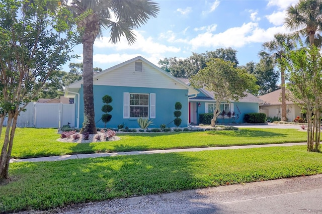 single story home featuring fence, stucco siding, and a front lawn