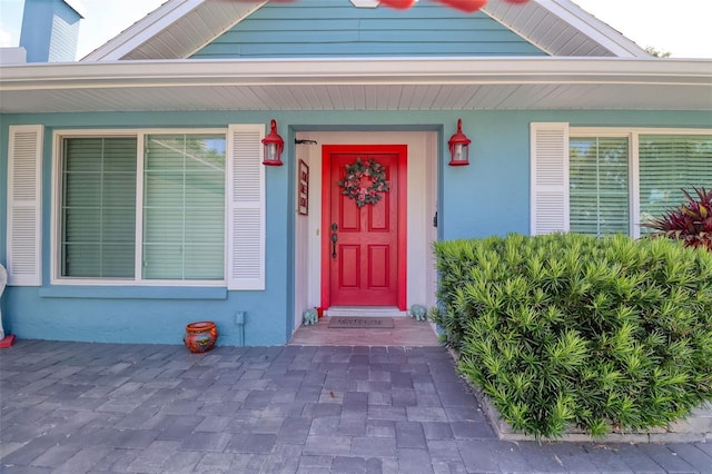view of exterior entry featuring stucco siding