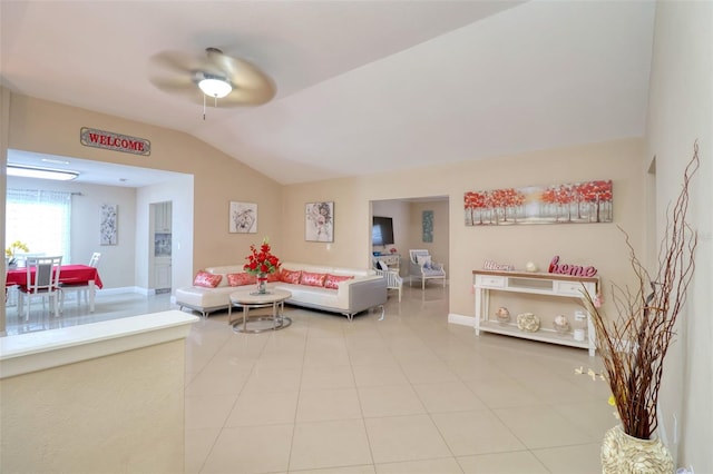 tiled living area with baseboards, a ceiling fan, and lofted ceiling