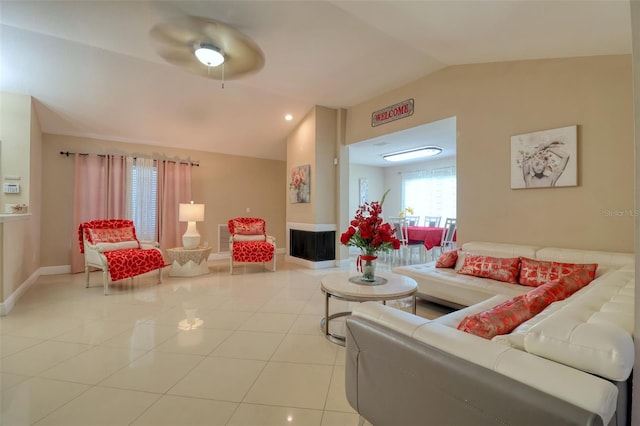 tiled living room featuring baseboards, a ceiling fan, and lofted ceiling