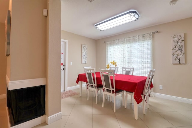 dining space with baseboards and tile patterned flooring
