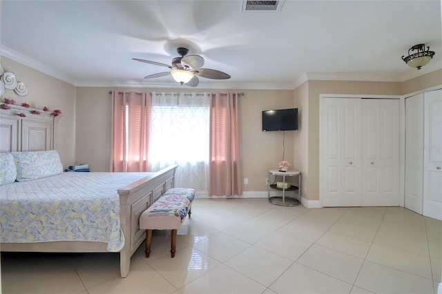 bedroom with crown molding, multiple closets, visible vents, and light tile patterned floors
