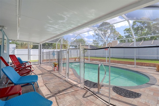 view of swimming pool featuring a fenced in pool, a fenced backyard, glass enclosure, and a patio area