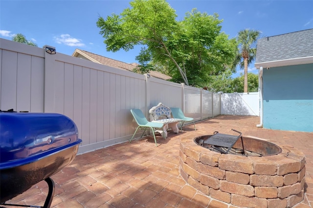 view of patio with a fenced backyard, an outdoor fire pit, and grilling area