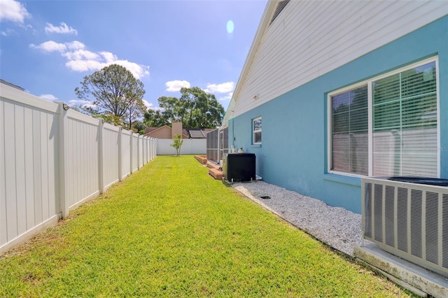 view of yard with central AC unit and a fenced backyard