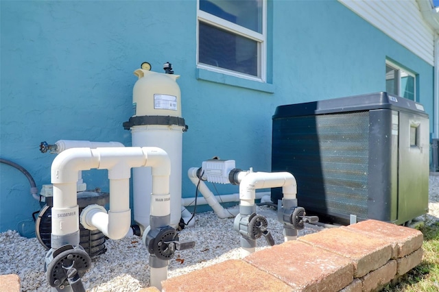 exterior space featuring pump and stucco siding
