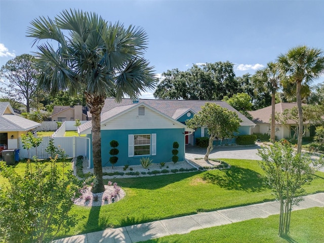 view of front of house with stucco siding, a front lawn, and fence
