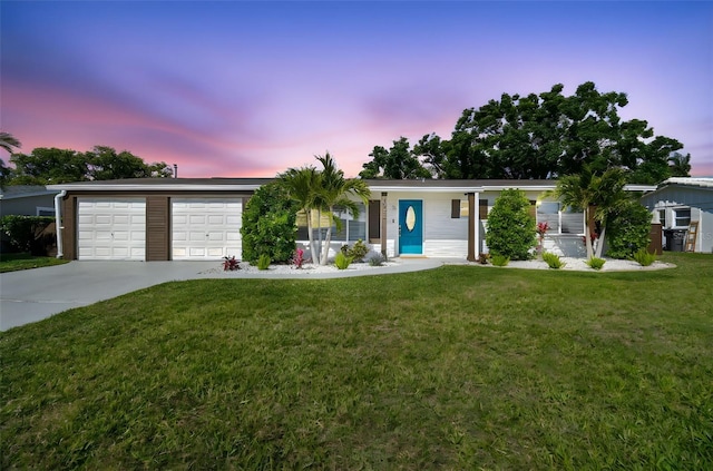 ranch-style home with an attached garage, a yard, and driveway