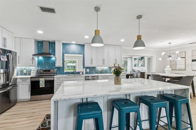 3922 Fontainebleau Dr, Tampa, FL 33634 - kitchen featuring stainless steel appliances, wall chimney exhaust hood, a sink, white cabinets, and ornamental molding