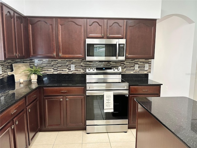 2820 Pankaw Ln, Valrico, FL 33596 - kitchen with stainless steel appliances, light tile patterned floors, and dark stone countertops
