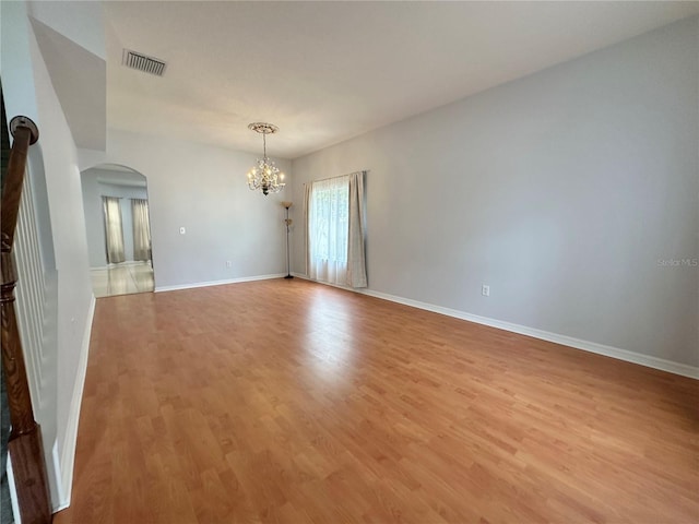 2820 Pankaw Ln, Valrico, FL 33596 - empty room featuring arched walkways, a chandelier, light wood-style flooring, and baseboards